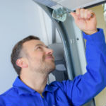 Repair man going through garage door repair the most common problems checklist